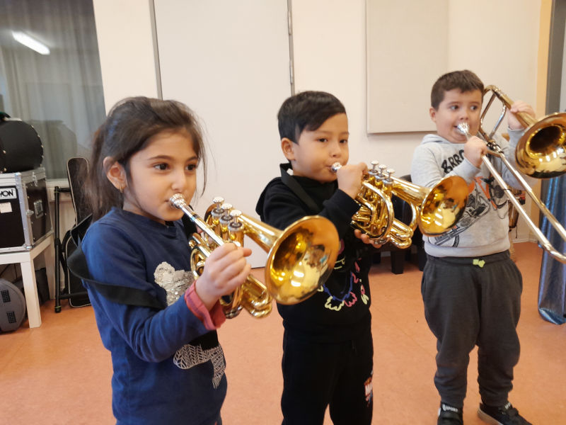 Kinder spielen Blasinstrumente des Elbphilharmonie-Klangmobils